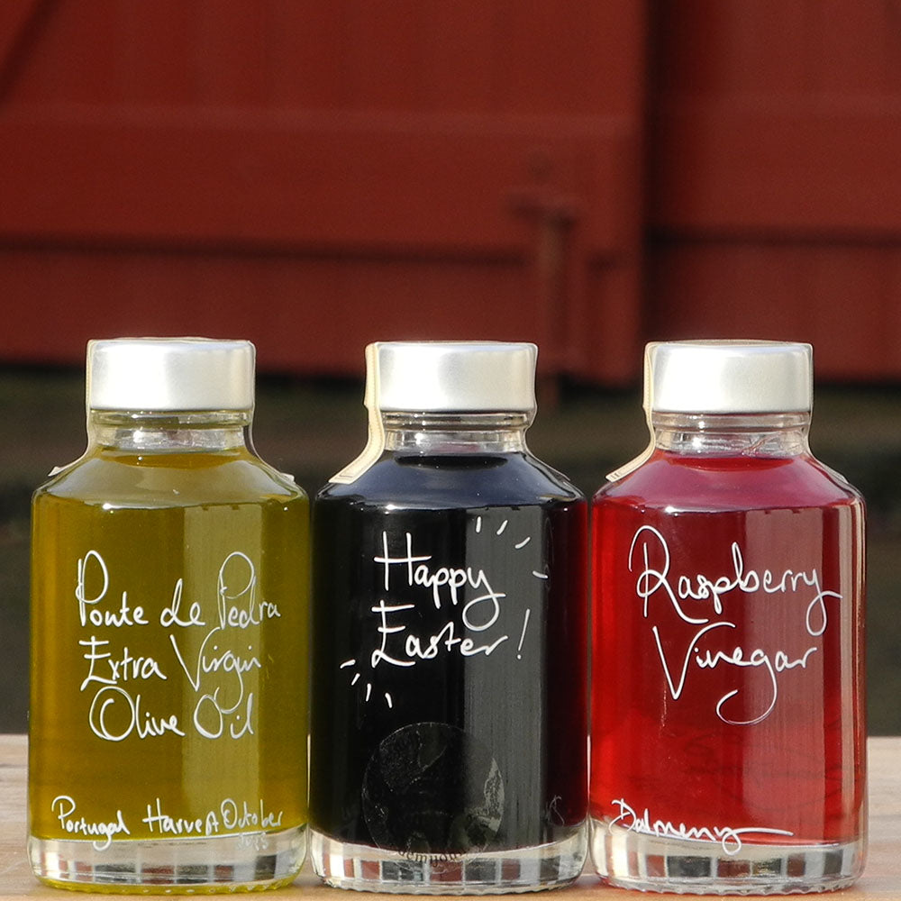 Mini Spring Bread Dipper Set with Portuguese Extra Virgin Olive Oil, Black Garlic Balsamic Vinegar and Raspberry Vinegar in 100ml bottles with handwritten labels in white pen, the middle bottle says 'Happy Easter!'