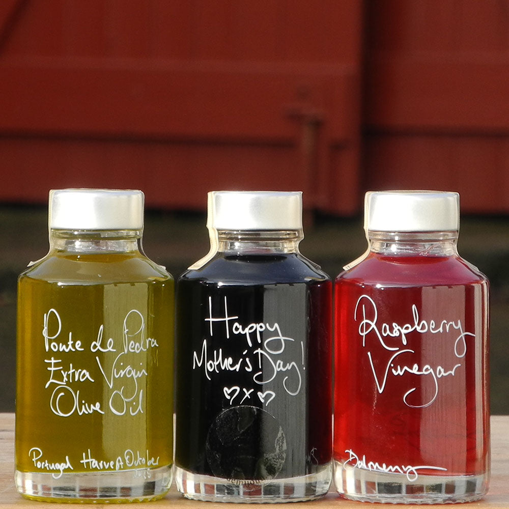 Mini Spring Bread Dipper Set with Portuguese Extra Virgin Olive Oil, Black Garlic Balsamic Vinegar and Raspberry Vinegar in 100ml bottles with handwritten labels in white pen, the middle bottle says 'Happy Mother's Day!'