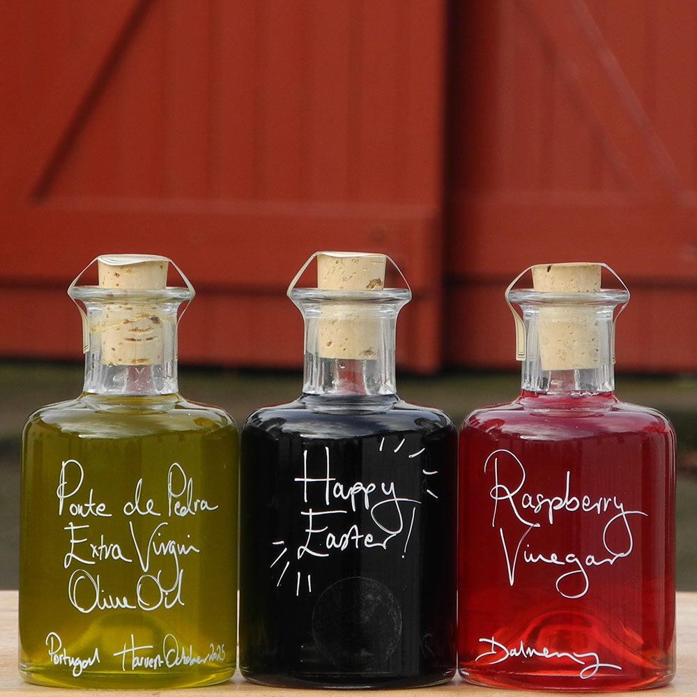 Spring Bread Dipper Set with Portuguese Extra Virgin Olive Oil, Black Garlic Balsamic Vinegar and Raspberry Vinegar in 200ml bottles with handwritten labels in white pen, the middle bottle says 'Happy Easter!'