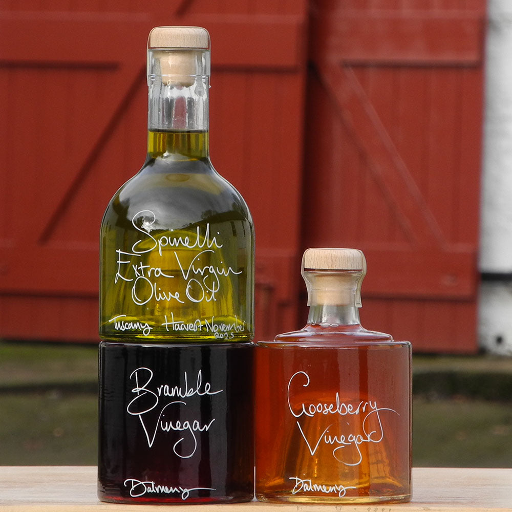 The Tuscan Oil and Vinegar Stacking Gift Set where three clever stacking Impilabile 250ml bottles have been filled with our fresh Spinelli Tuscan Extra Virgin Olive Oil, Gooseberry Vinegar and our Bramble Vinegar, both from Edinburgh. The labels are handwritten in white pen in front of the red shutters at Glenlair Steading.